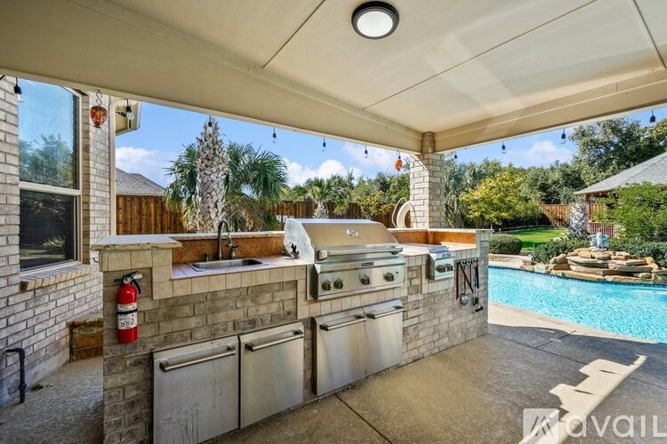 An outdoor kitchen area with a grill and sink.