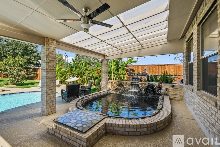 A patio with a pool and a ceiling fan.