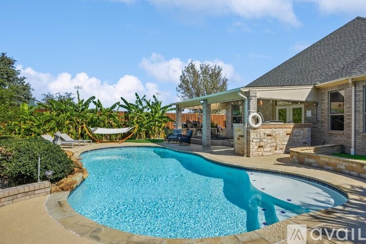 A large swimming pool in a backyard with a house in the background.