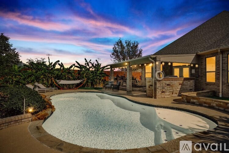 A backyard with a pool and a hammock.