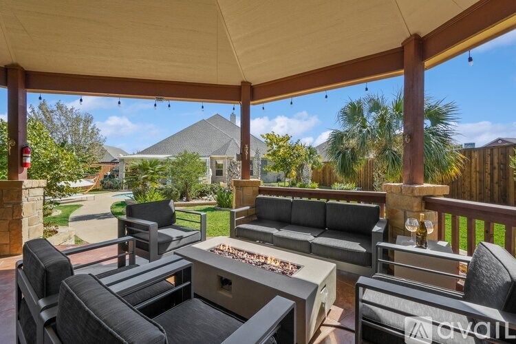 A patio with a table and chairs and a grill.