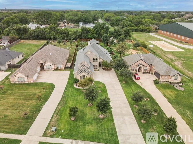 A bird's eye view of a residential area with houses and green lawns.