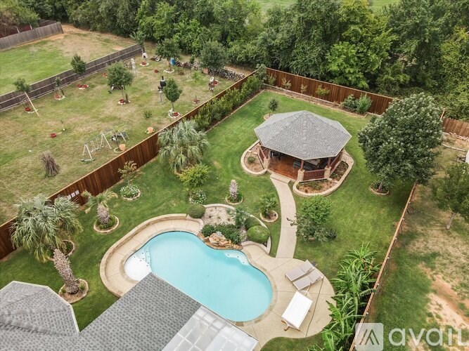 A backyard with a pool and a gazebo.