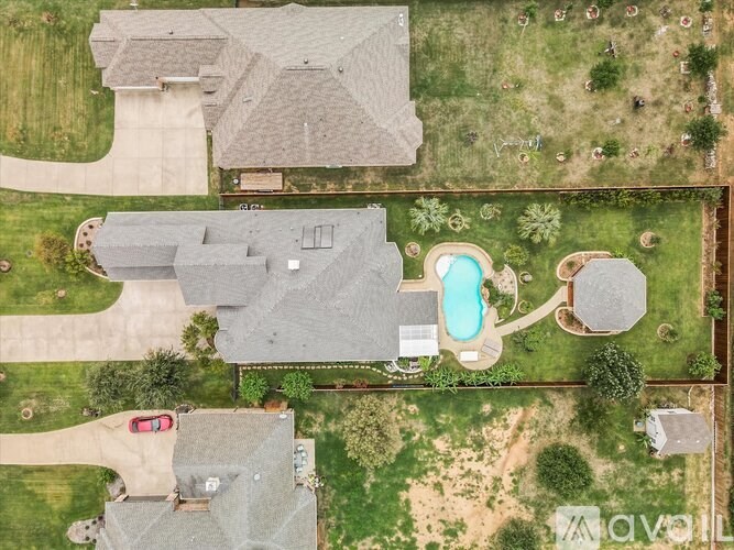 A bird's eye view of a house with a swimming pool and a car parked in the driveway.