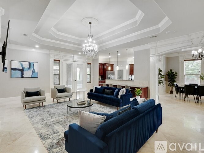 A living room with a blue sofa and a chandelier.