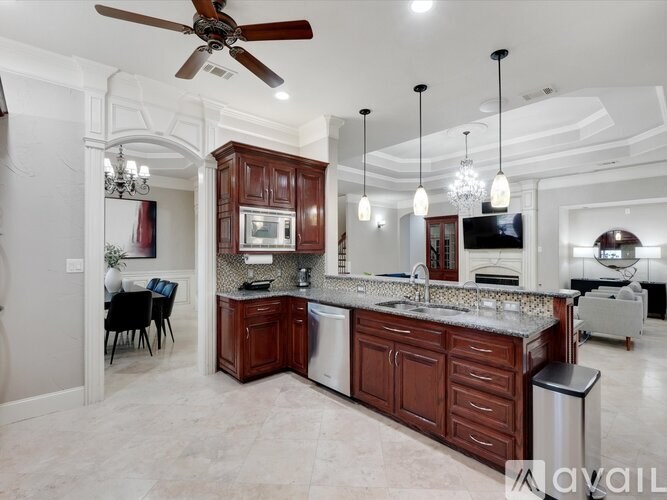 A kitchen with a large island and a ceiling fan.