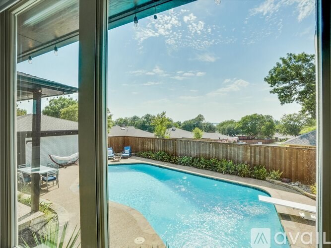 A pool in a backyard with a wooden fence.