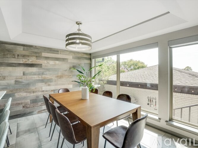 A dining room with a wooden table and chairs.