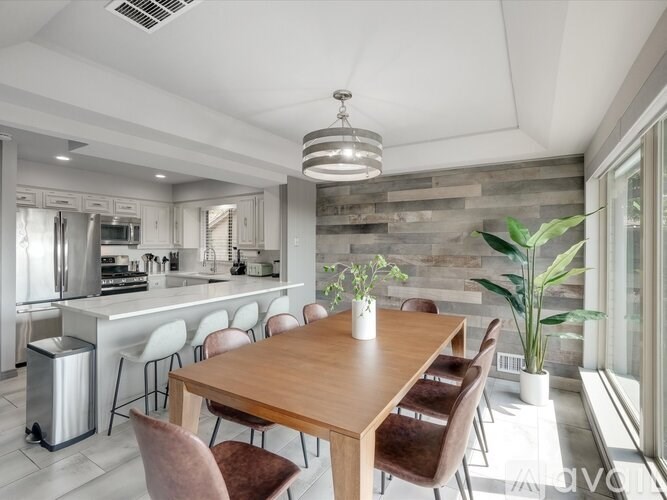 A modern kitchen with a wooden dining table and chairs.