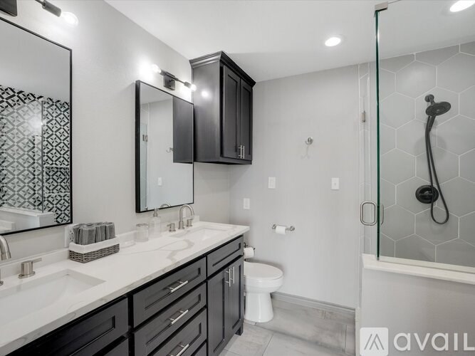 A bathroom with a white countertop and black cabinets.