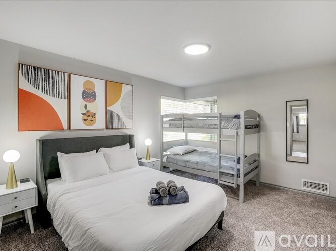 A bedroom with a large bed and a bunk bed.