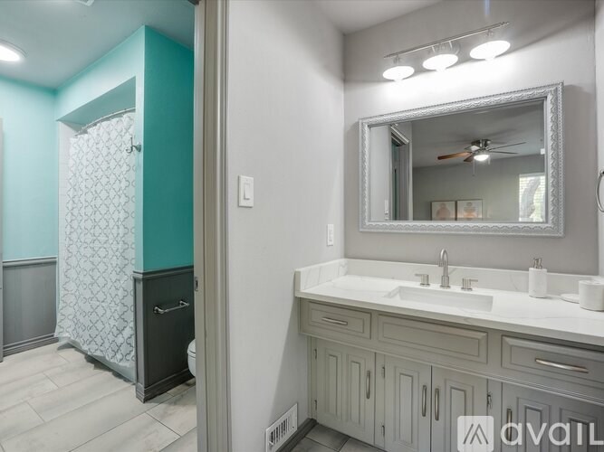 A bathroom with a white sink and a mirror above it.