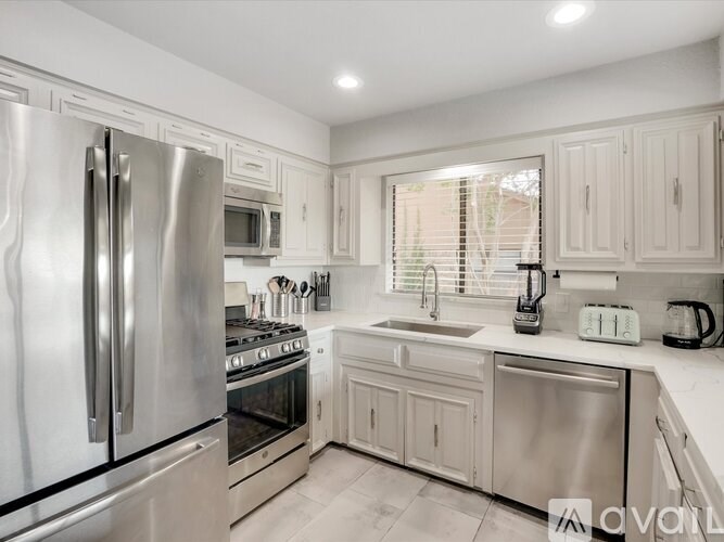 A modern kitchen with stainless steel appliances and white cabinets.