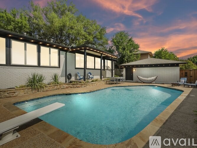 A pool with a slide and a building behind it.