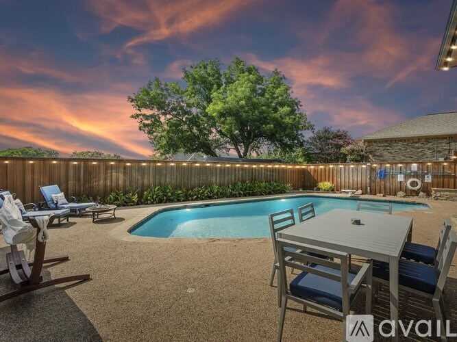 A backyard with a pool and a table set up for dining.