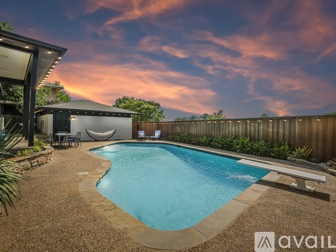 A backyard with a pool and a hammock.