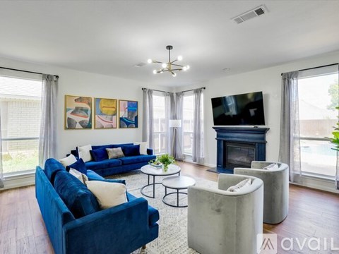 A living room with a blue couch and a fireplace.