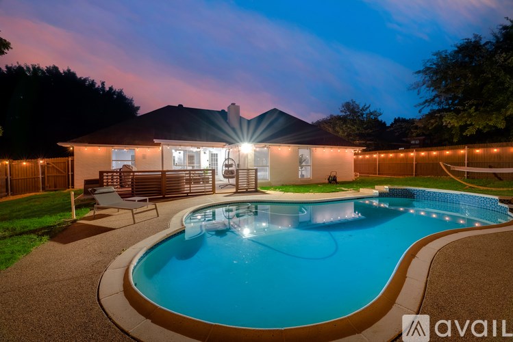 A house with a pool in the backyard at night.