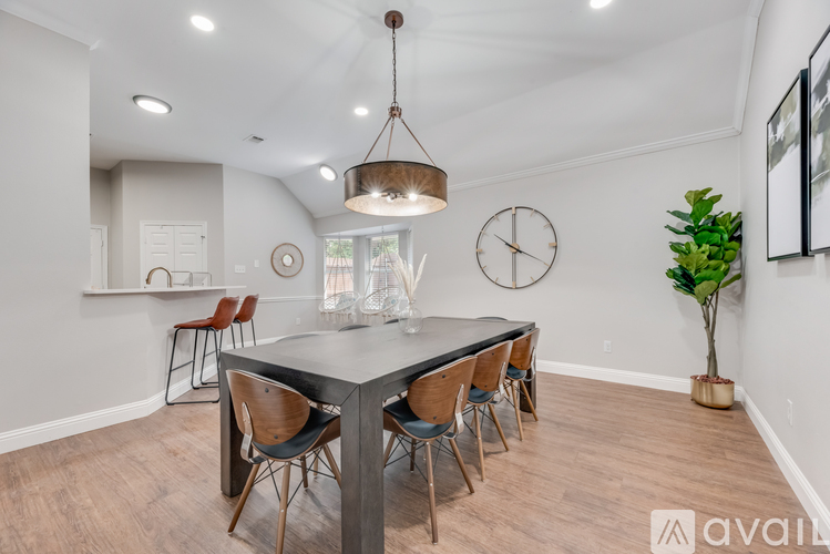 A dining room with a table and chairs.