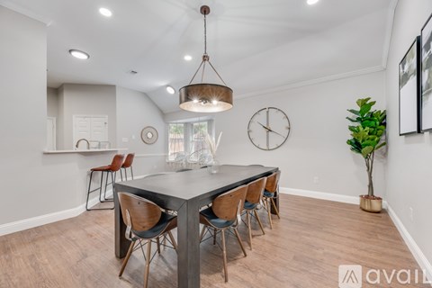 A dining room with a table and chairs.