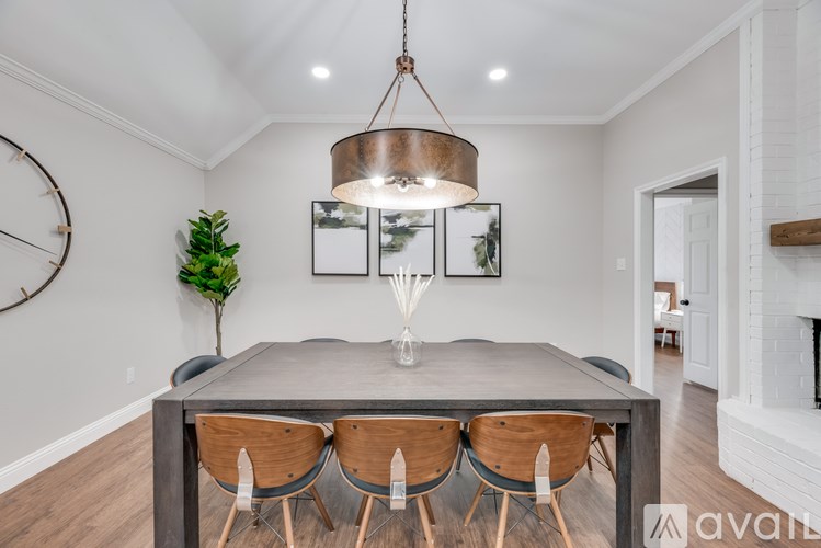 A modern dining room with a grey table and wooden chairs.