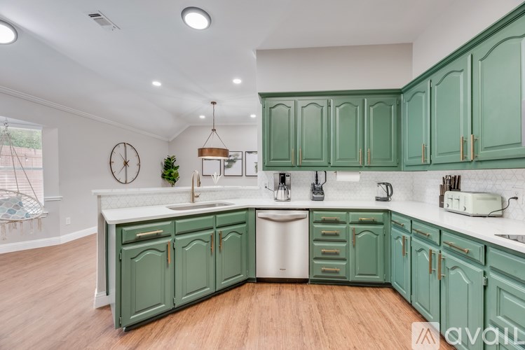 A kitchen with green cabinets and a white sink.