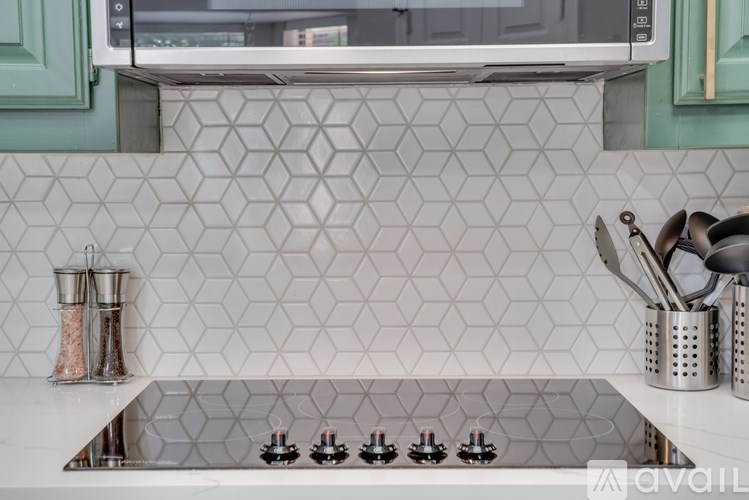 A kitchen with a white counter top and a stove with four burners.