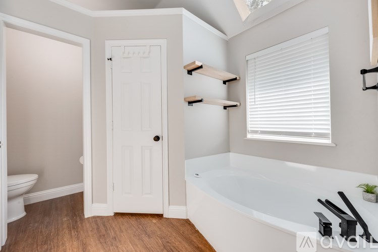A white bathroom with a tub, toilet and sink.