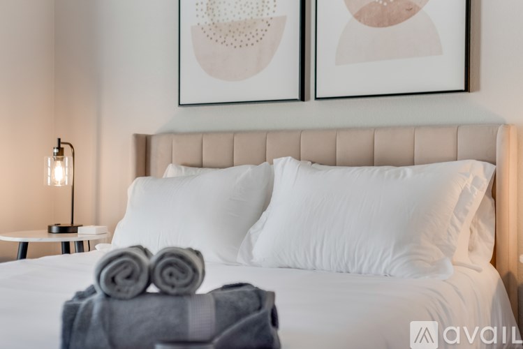 A neatly made bed with white pillows and a grey blanket.