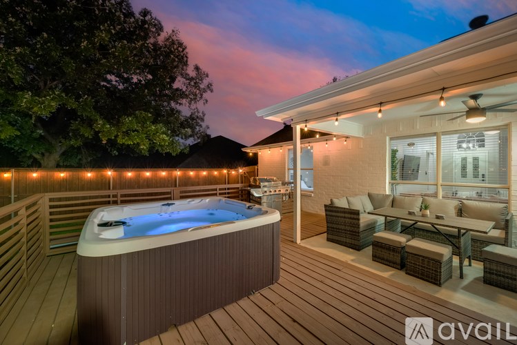 A hot tub is on a deck with lights around it.