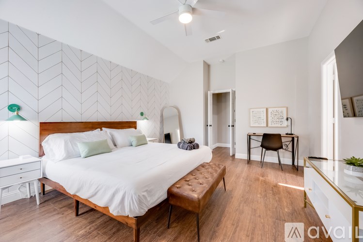 A bedroom with a large bed and a bench in front of it.