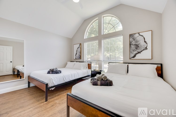 A bedroom with two beds and a large window.