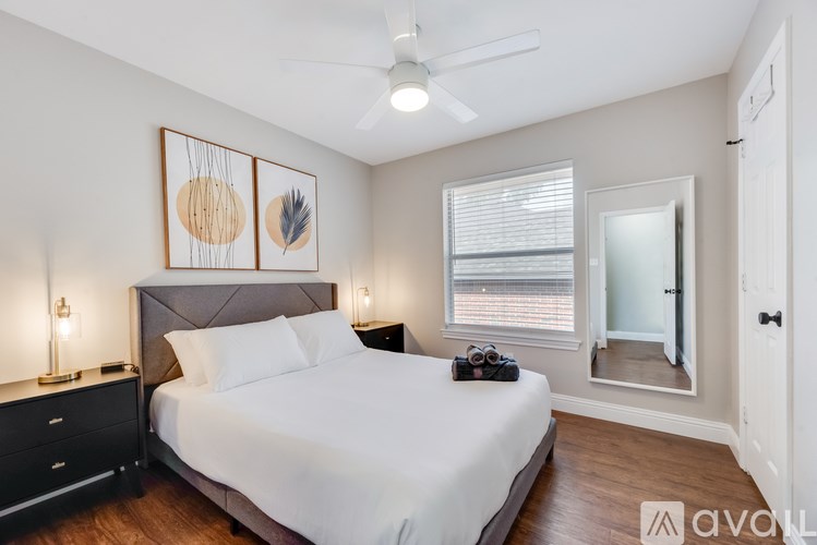 A bedroom with a bed, nightstands, and a ceiling fan.