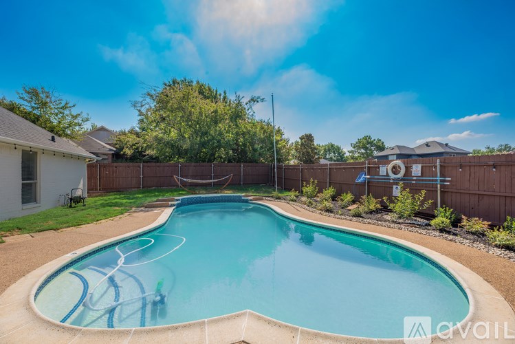 A swimming pool surrounded by a fence and some greenery.