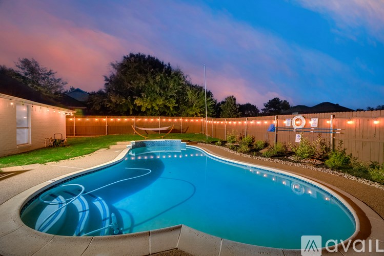 A swimming pool with lights around it at dusk.
