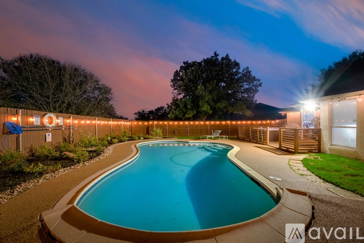 A swimming pool surrounded by lights at night.