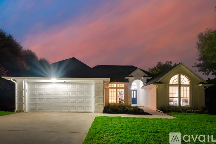 A house with a lit garage door at night.