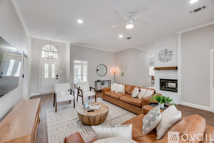 A living room with a brown leather couch, a coffee table, and a fireplace.
