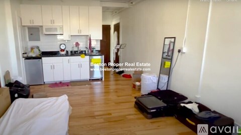 A kitchen with white cabinets and a wooden floor.