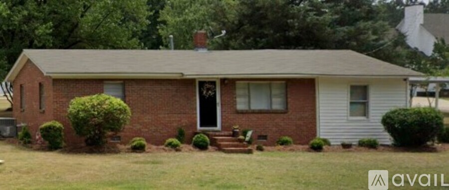 A house with a brick facade and a white door is for sale.