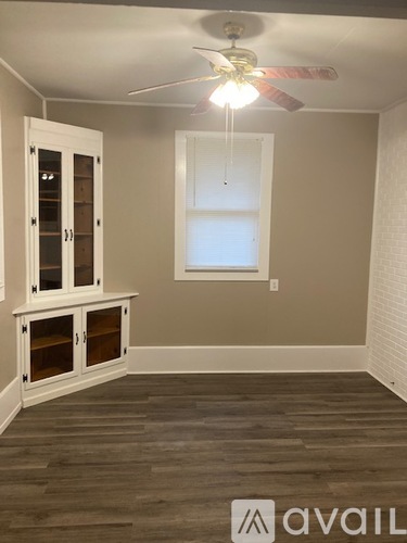 A room with a window and a cabinet with glass doors.