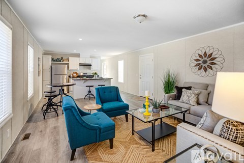 A living room with a blue chair and a glass table.