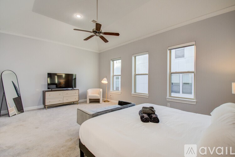 A bedroom with a large bed, a television, and a mirror.