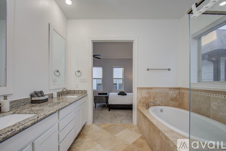 A bathroom with a tub, sink, and mirror.