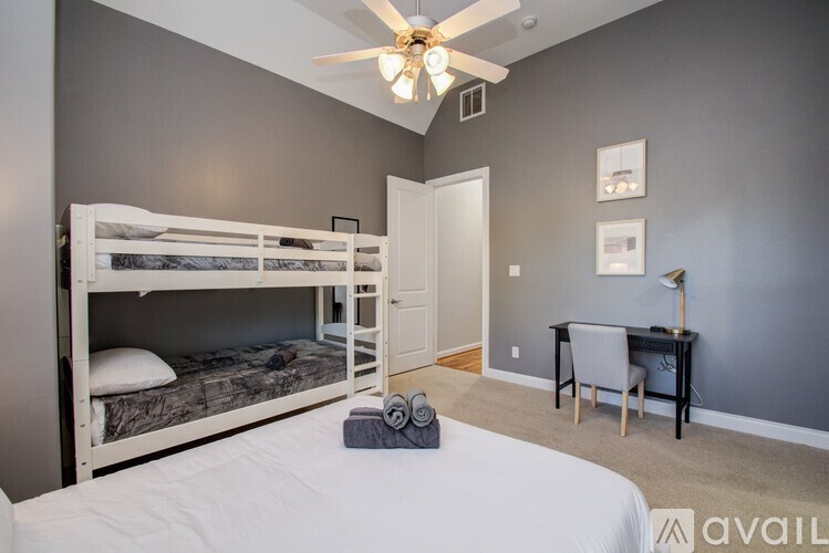 A bedroom with a bunk bed and a desk.