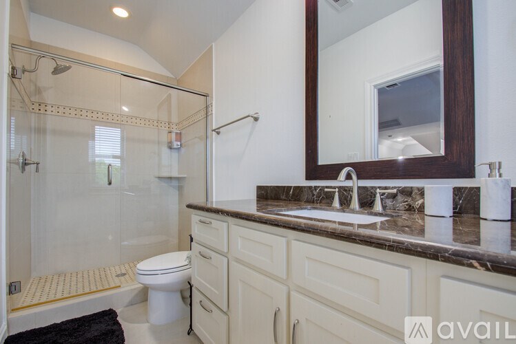 A bathroom with a toilet, sink, and shower.