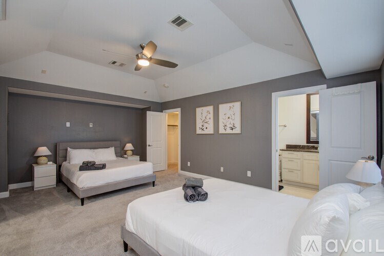 A bedroom with a large bed and a ceiling fan.
