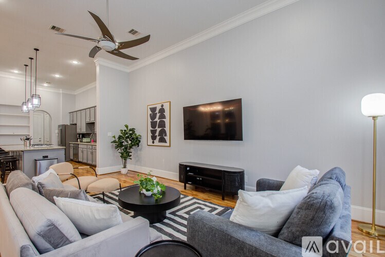A living room with a grey couch and a black and white rug.