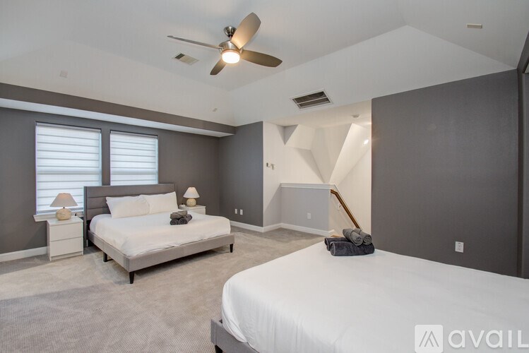 A bedroom with a bed, nightstand, and window with blinds.