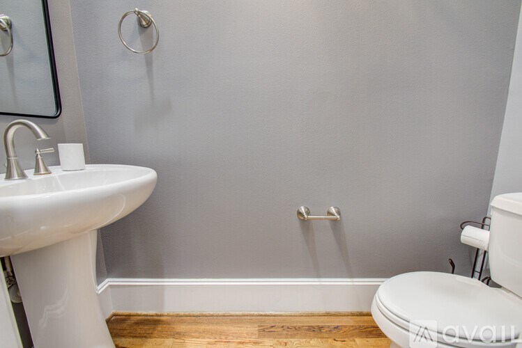 A white toilet sits next to a white sink in a bathroom.